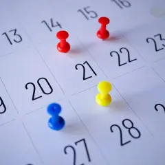 Kolorowe pinezki na kalendarzu zaznaczają dni, które czekają na zaplanowanie. Ile urlopu jeszcze zostało?