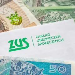 Koperta ZUS na tle polskich banknotów. Symbolizuje ubezpieczenie chorobowe i świadczenia socjalne.
