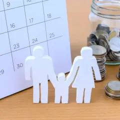 Rodzina z monetami i kalendarzem. Oszczędzanie na zasiłek rodzinny.