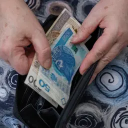Dłonie chowają do portmonetki banknoty 50 i 200 zł. Może to pieniądze na życie, albo na pokrycie kosztów związanych z rentą socjalną.