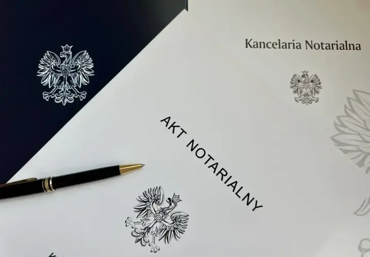 Akt notarialny na najem okazjonalny czeka na podpis. Długopis i orzeł w koronie symbolizują formalność i bezpieczeństwo transakcji.
