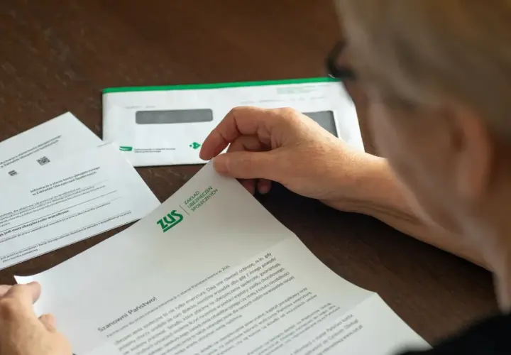 Osoba przegląda dokument ZUS. Może to być informacja o stanie konta lub zwrot nadpłaty.