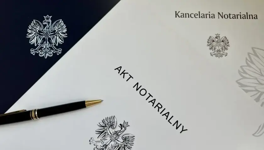 Akt notarialny na najem okazjonalny czeka na podpis. Długopis i orzeł w koronie symbolizują formalność i bezpieczeństwo transakcji.