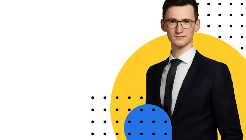 Mężczyzna w garniturze i okularach na tle żółtego koła i niebieskiego okręgu z kropkami.