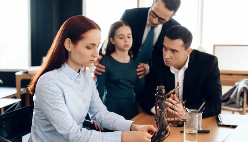 Rodzina z prawnikiem przy biurku, dyskutująca o sytuacji, kiedy nie należy się zachowek po rodzicach.